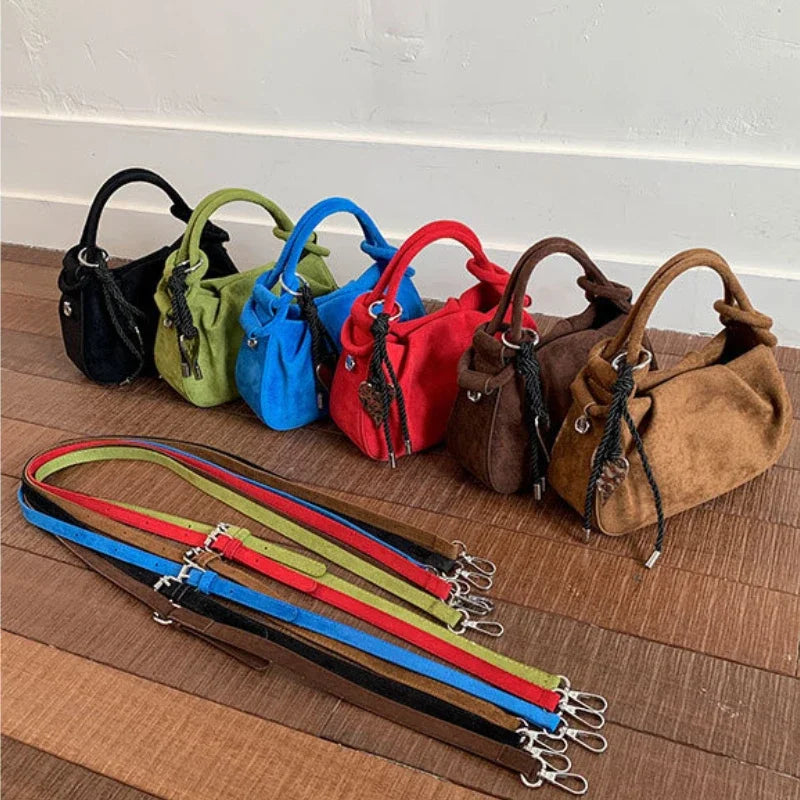 Set of small suede hobo crossbody bags in black, green, blue, red, brown, and coffee tones.