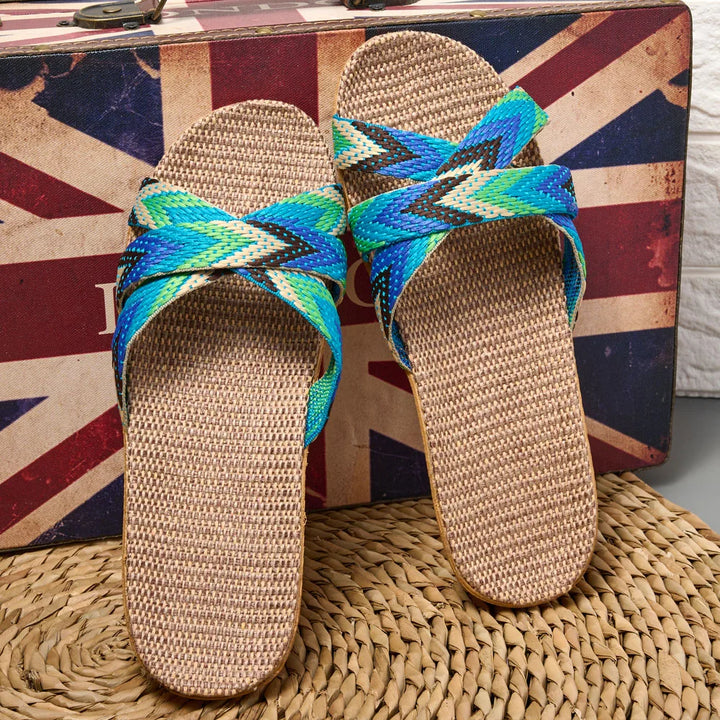 Pair of colorful sandals with woven straps on a textured surface