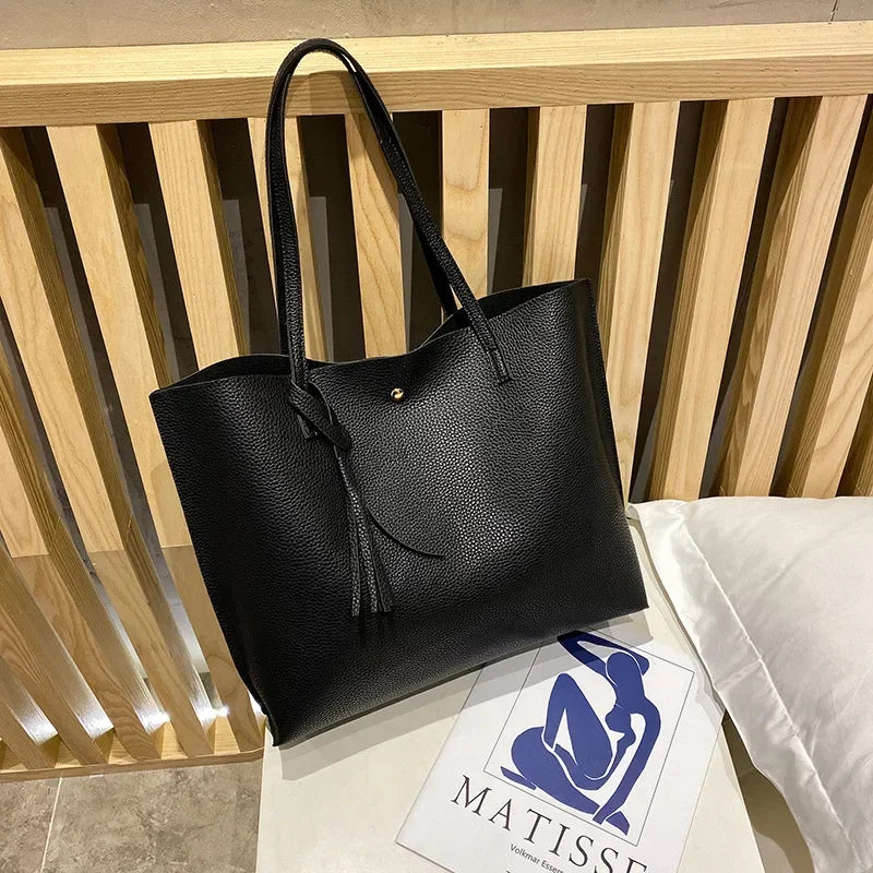 Black tote bag on a wooden surface with a Matisse logo in the background