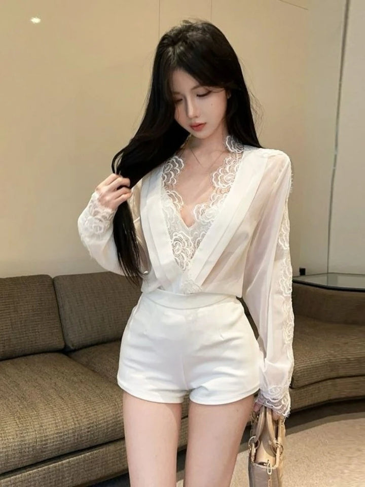 Woman wearing a white lace top and shorts in an indoor setting