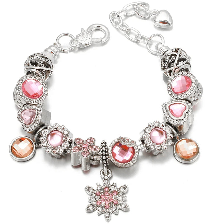 Silver charm bracelet with pink gemstones, teardrop charms, and a round flower pendant