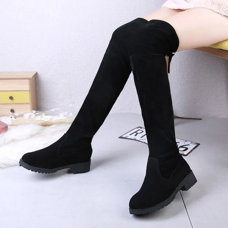 Black knee-high boots worn by a person on a light gray floor.