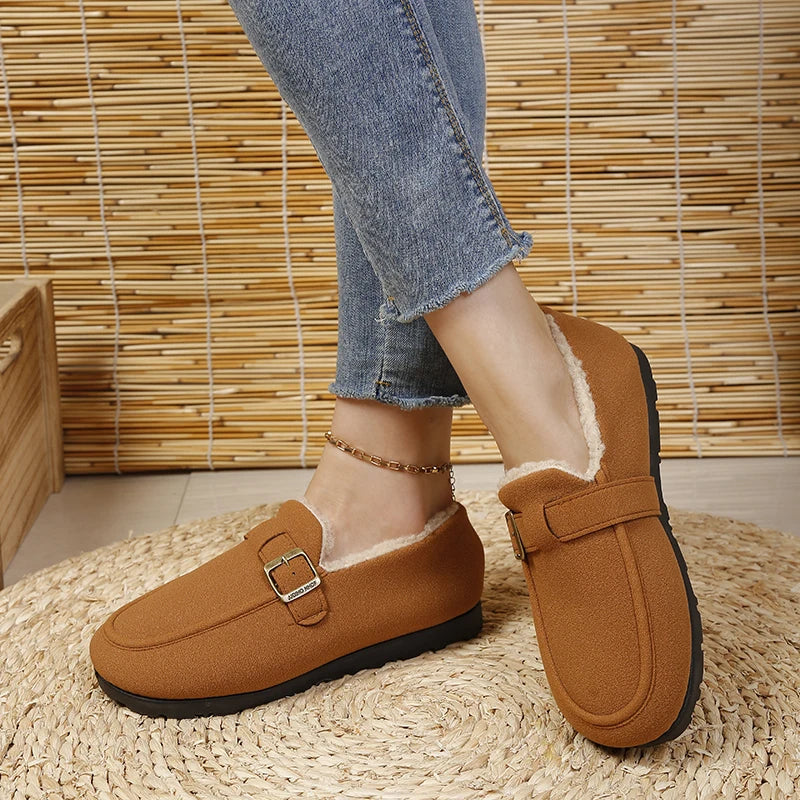 Brown slip-on loafer with gold buckle and short plush lining, on foot