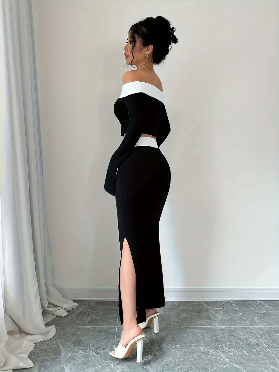 Side view: off-shoulder black crop top with white trim and high-slit mermaid skirt