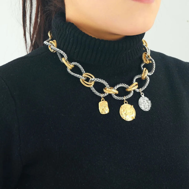 Chunky twisted-link necklace in gold and silver with three small dangling charms