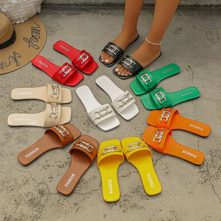 Assorted flat leather sandals with chain-strap buckles in multiple colors