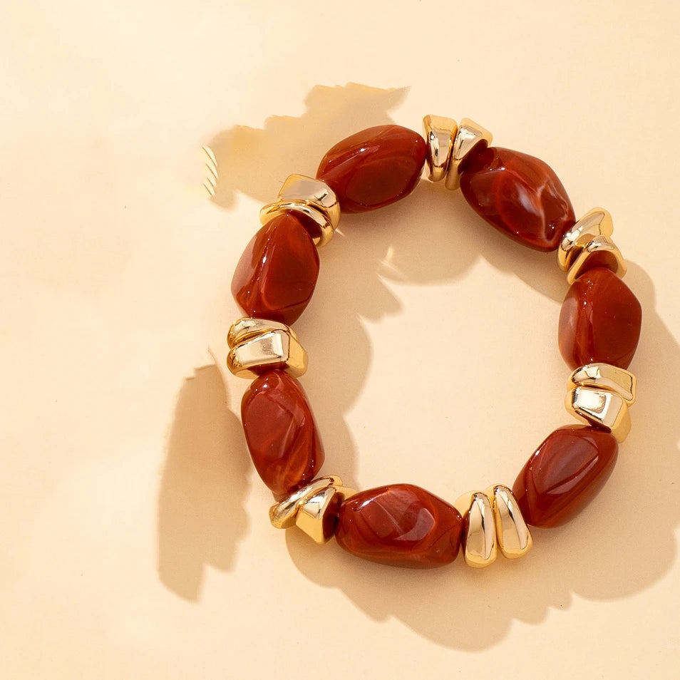 Gold-tone acrylic bead bracelet with deep red irregular beads and chunky link accents