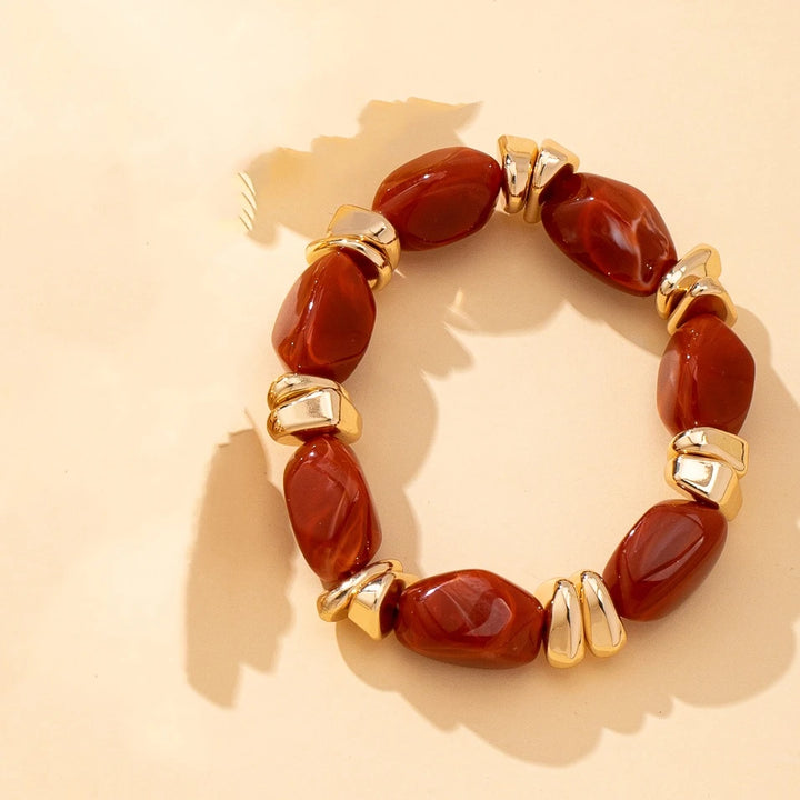 Gold-tone acrylic bead bracelet with deep red irregular beads and chunky link accents
