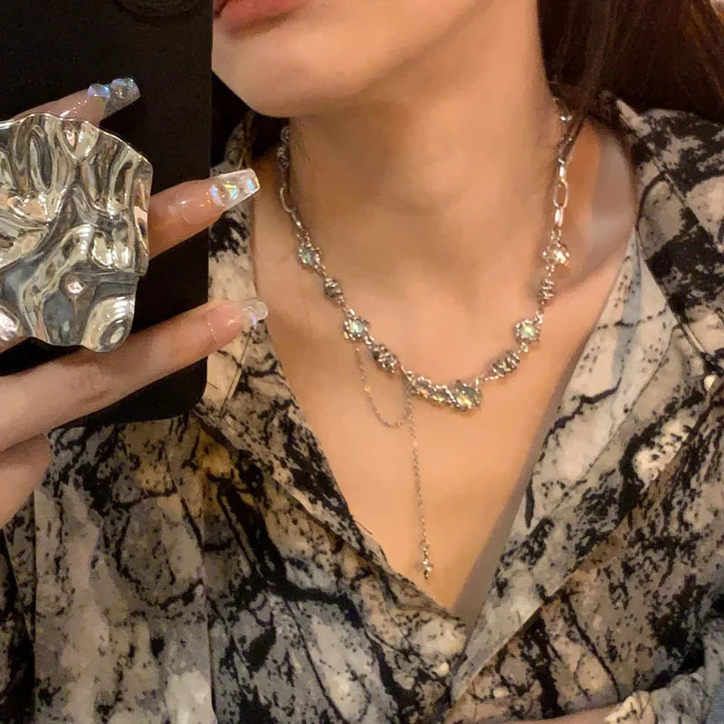 Close-up of a person wearing a silver necklace with a patterned top.