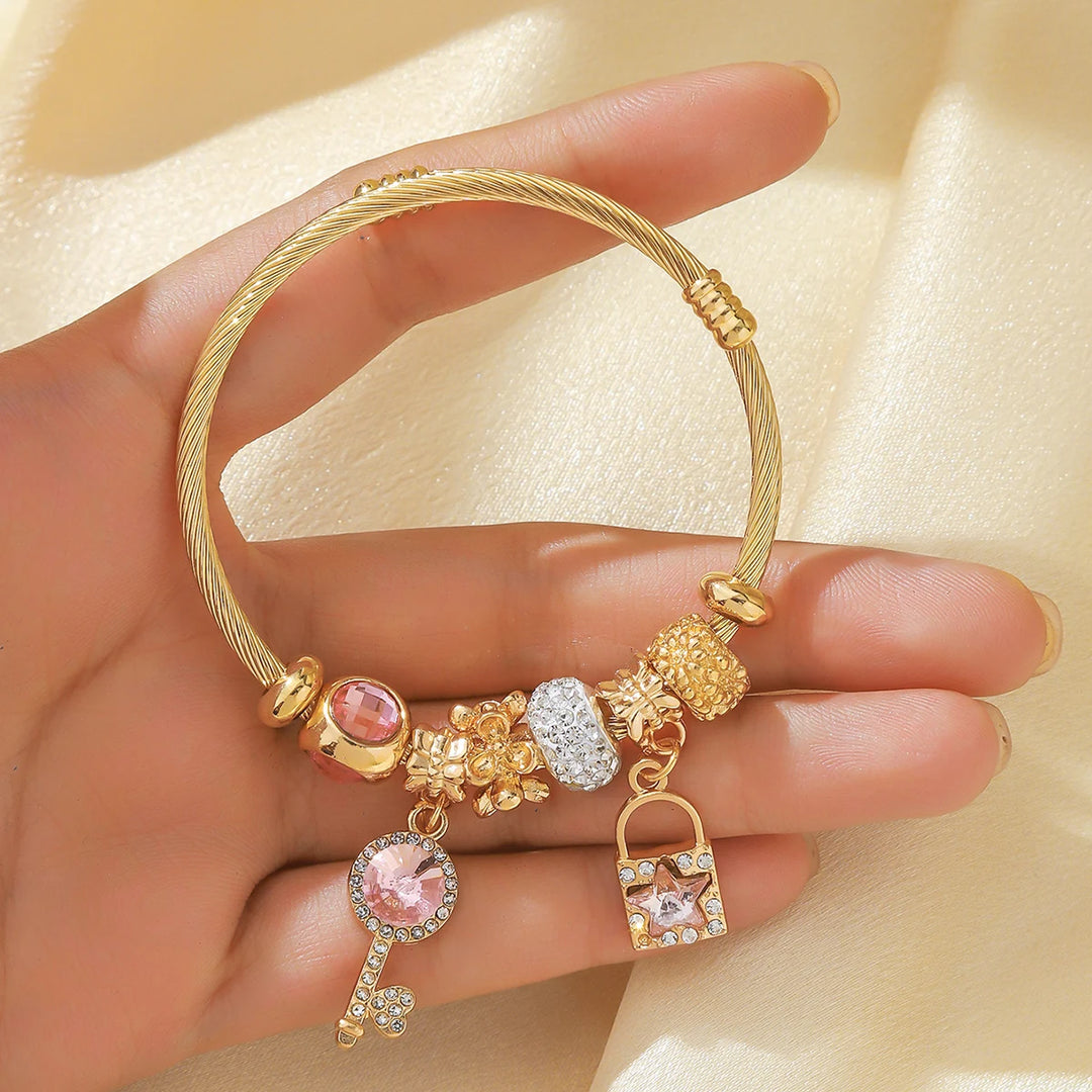 Goldfarbener Armreif mit rosafarbenen und weißen Perlen, runde Strass-Charms und Anhänger