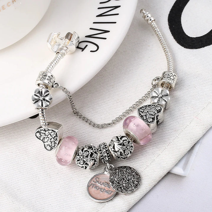 Silver-plated bracelet with heart charms, pink crystal beads, and snake chain links