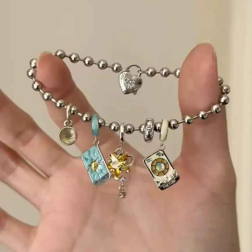 Bracelet with various charms on a hand against a neutral background