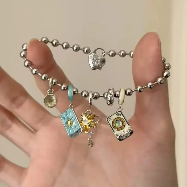 Bracelet with various charms on a hand against a neutral background