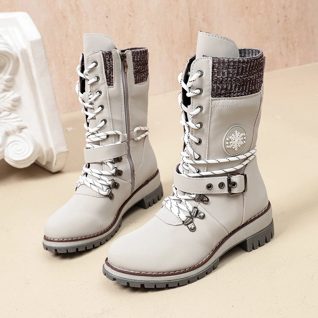 Women’s white lace-up winter boots with snowflake emblem, side knit panel, and tread sole.