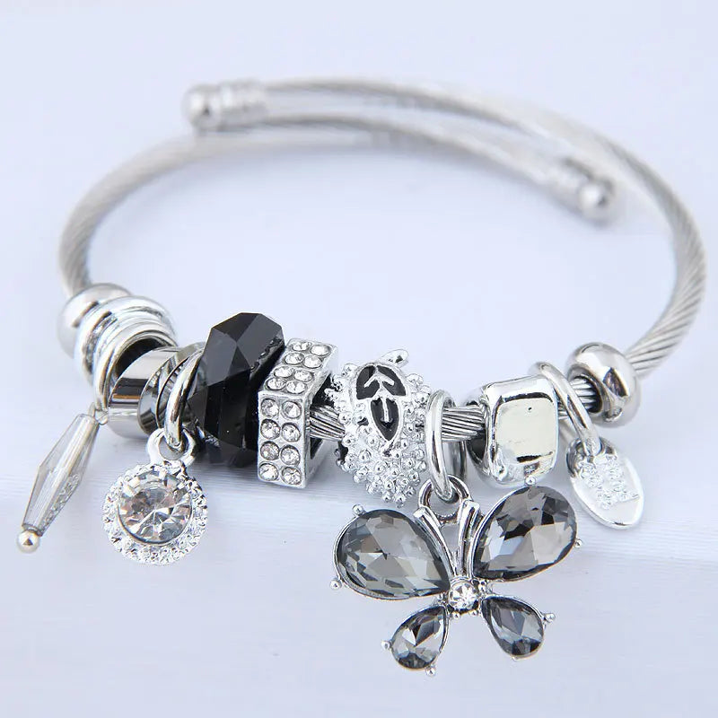 Stainless steel cuff bangle with dark crystal butterfly charms and dangling studs