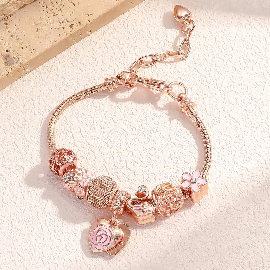 Rose gold charm bracelet with pink flower, rose heart charm, and heart link pendants