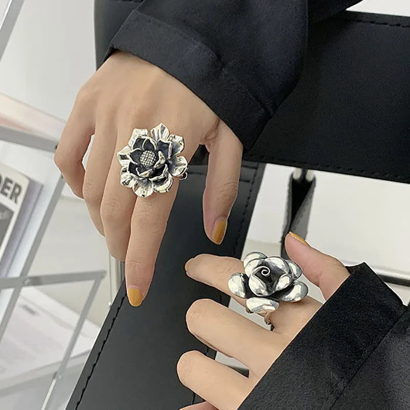Women’s 925 sterling silver flower ring with dark textured center bead on finger