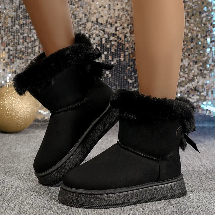 Black winter snow boots with faux fur cuffs, round toe, and bow ties on the sides