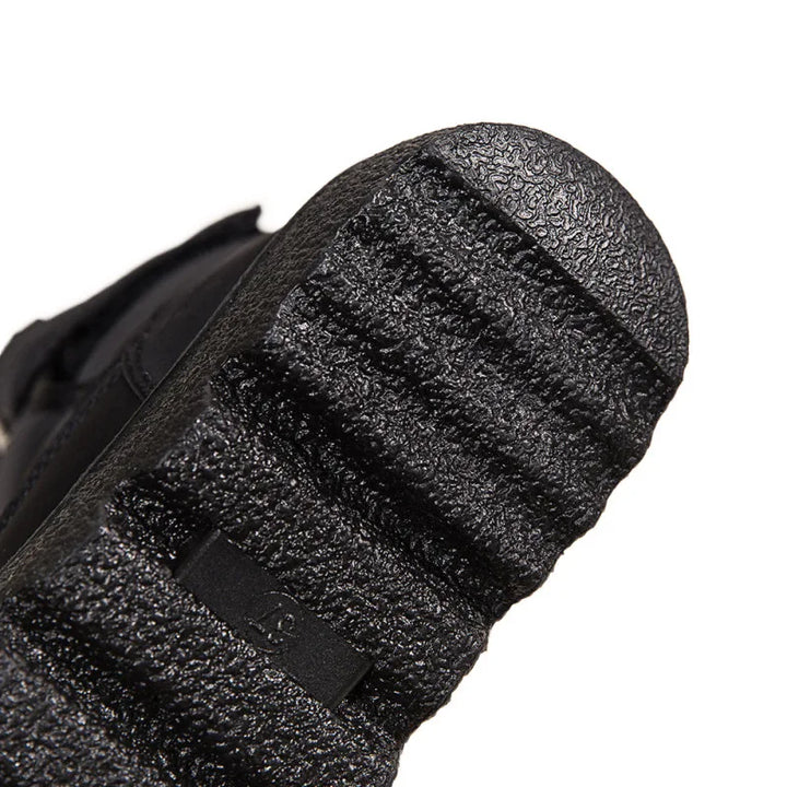 Close-up of a textured black shoe sole on a white background