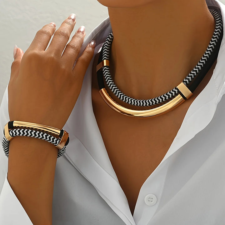 Necklace and bracelet with gold accents and black and white pattern worn by a person