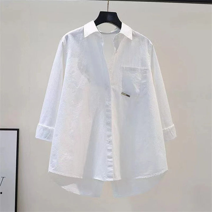 White shirt on a hanger against a plain background