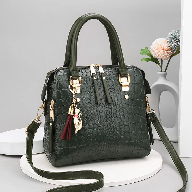 Black textured handbag with gold accents and a strap on a white surface.