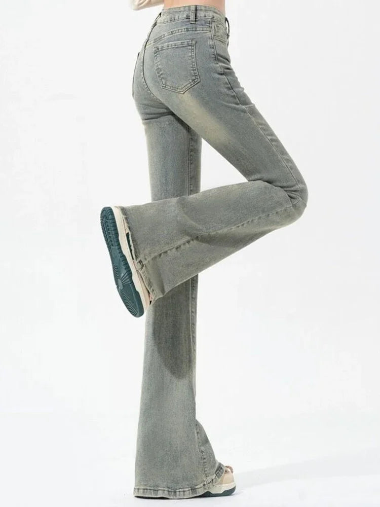 Gray flared jeans being worn on a white background