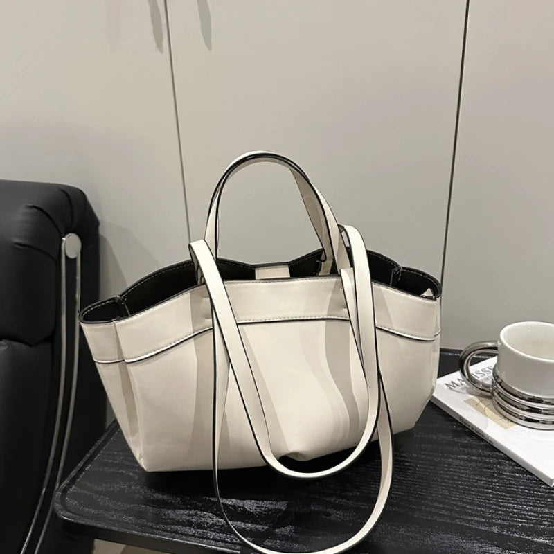 White handbag on a dark surface with a light gray background