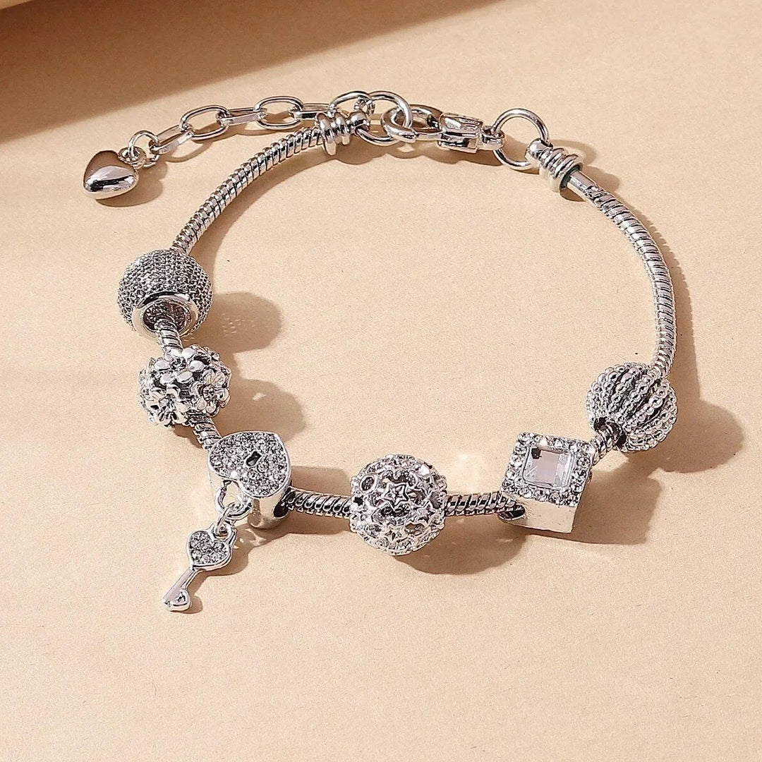 Silver charm bracelet with crystal beads, heart pendant, and small animal figure charms