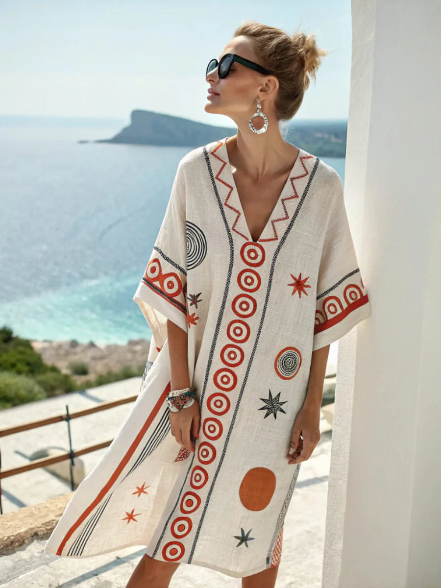White mini dress with V-neck embroidery and circular star-style print panels, short sleeves