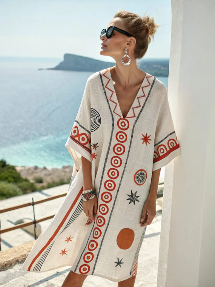 White mini dress with V-neck embroidery and circular star-style print panels, short sleeves