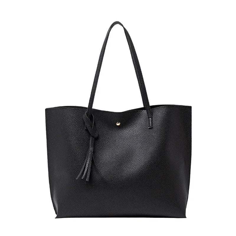 Black leather tote bag with a strap on a white background