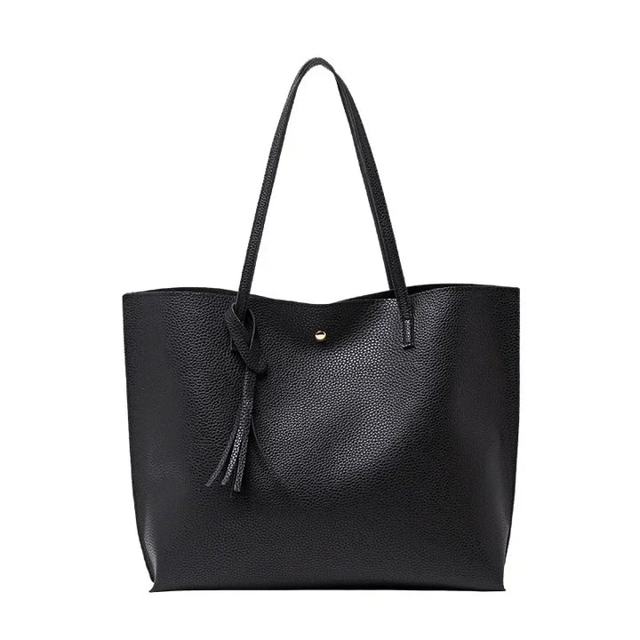 Black leather tote bag with a strap on a white background