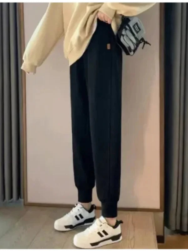 Women's Black Cuffed Joggers Styled With A Cream Sweatshirt And White Sneakers