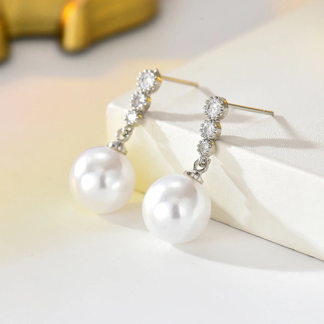 Silver-tone zircon and pearl drop dangle earrings with hook backs, side view