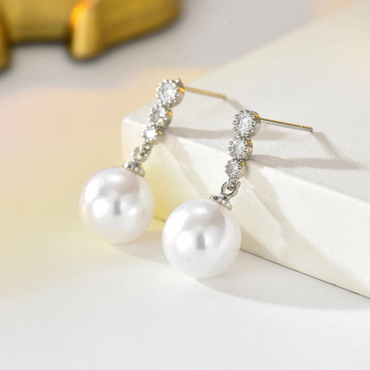Silver-tone zircon and pearl drop dangle earrings with hook backs, side view