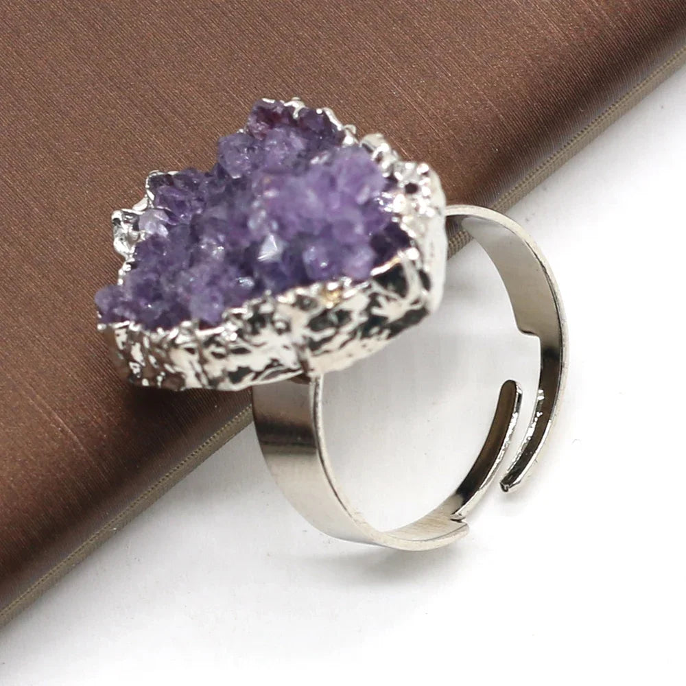 Silver ring with a purple crystal on a brown surface