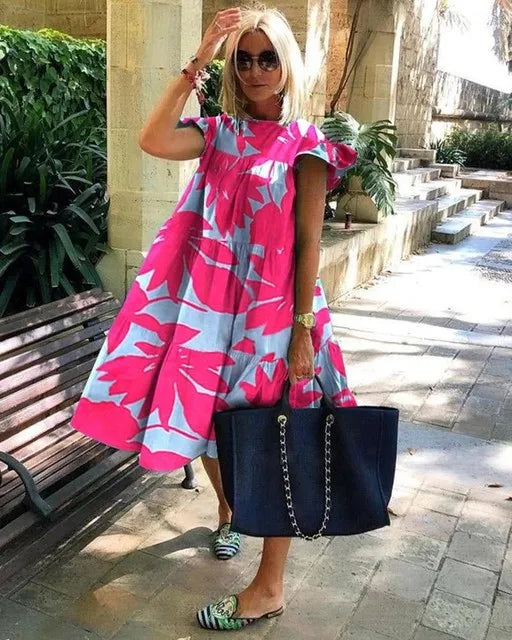 Hot pink midi dress with bold floral pattern, puff sleeves, and tiered skirt