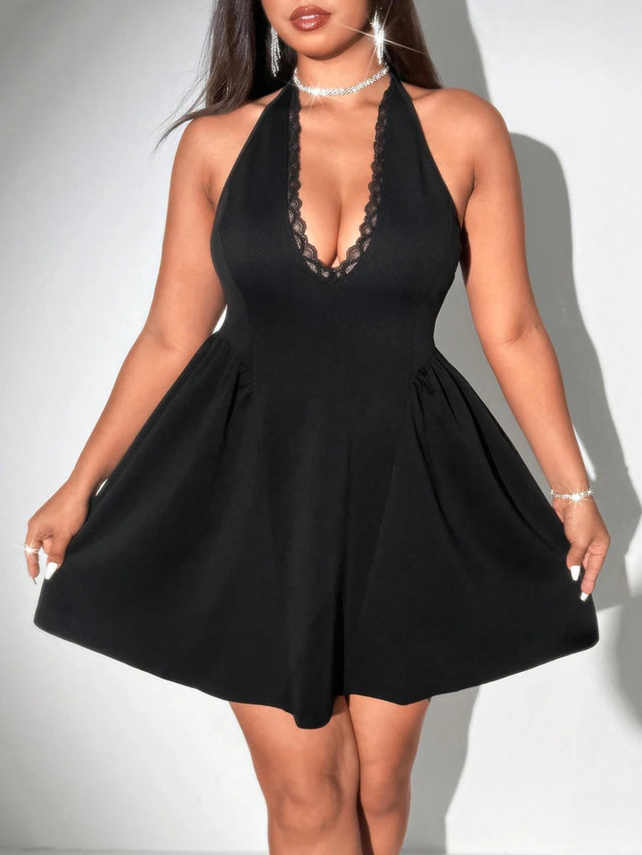 Black dress with lace detailing on a plain background