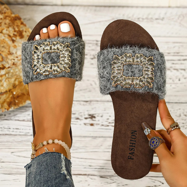 Brown sandal with decorative gray strap and 'FASHION' sole on a wooden floor.