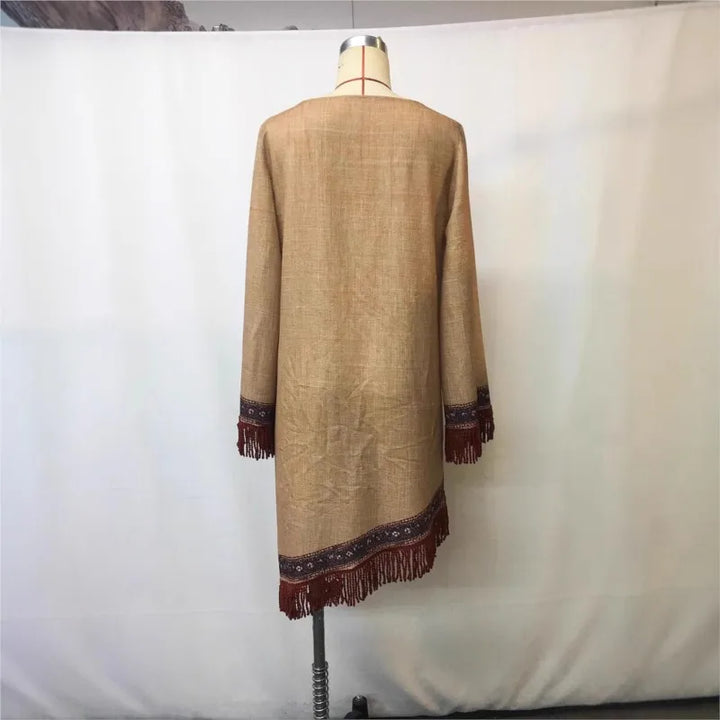 Beige coat with brown trim and fringes on a mannequin against a white background