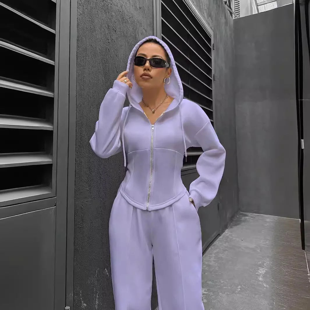Person wearing a light purple tracksuit standing in an urban setting.