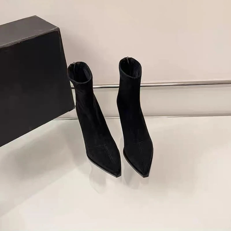 Black suede pointed-toe ankle boots with slim high heel, two shoes on display