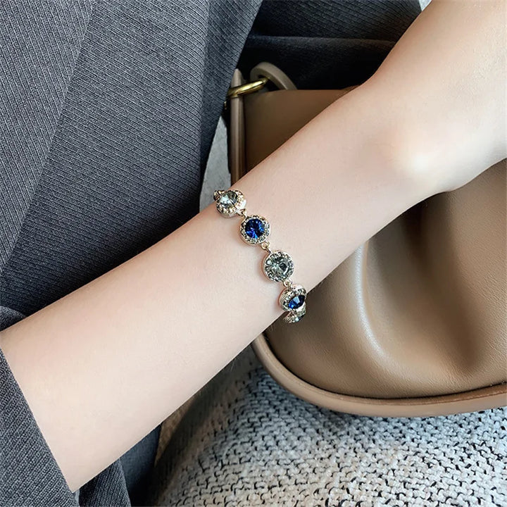 Silver-tone bracelet with round blue and clear stones on a fine chain