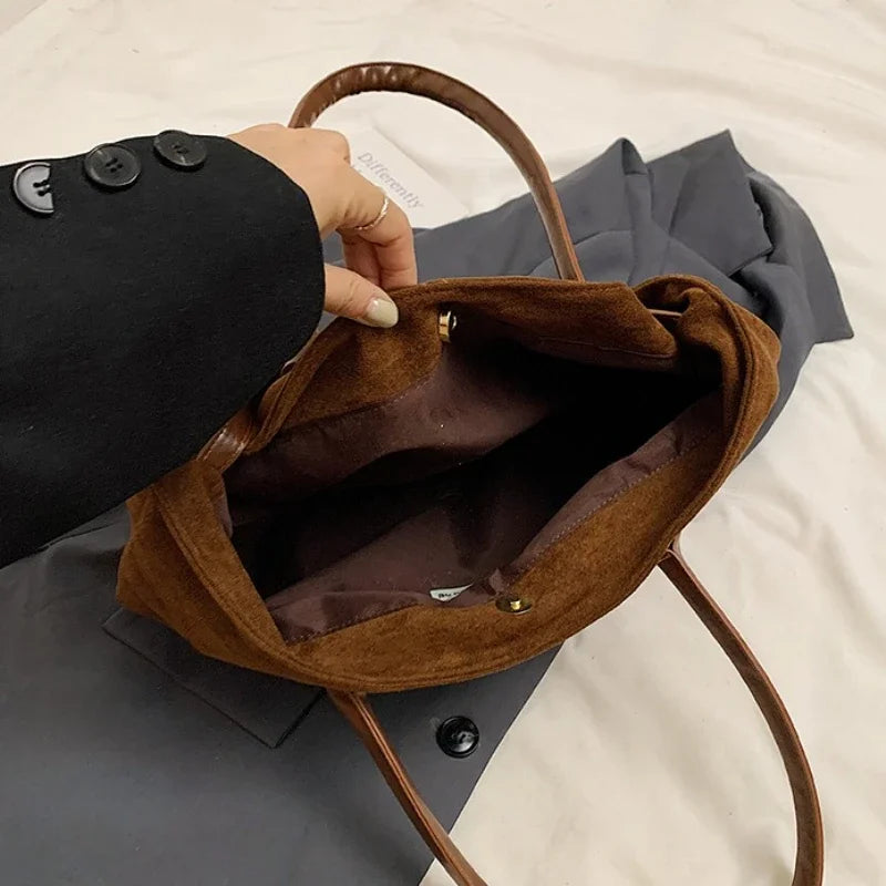 Women’s suede tote bag in brown with open top showing soft interior lining.