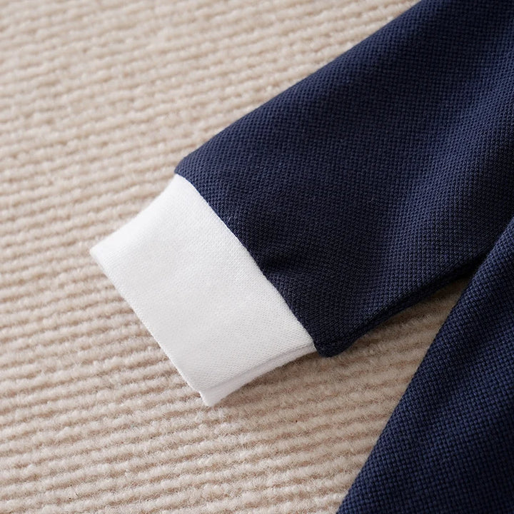 Close-up of a navy blue fabric with white trim on a beige carpet
