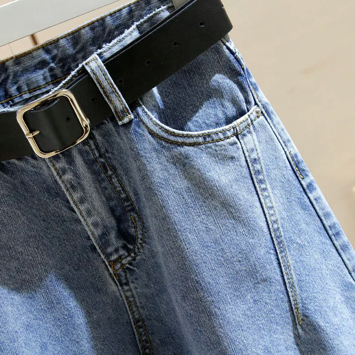 Women’s denim harem jeans close-up: black belt buckle and front pocket opening