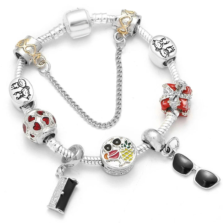 Silver bracelet with heart and key charms, ladybug charm, and red accent bead details