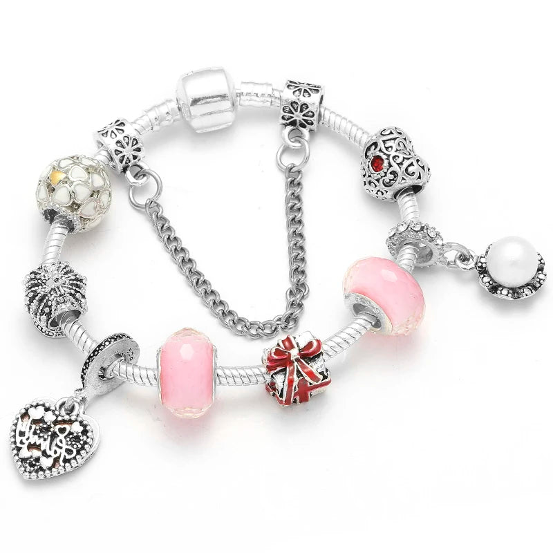 Silver bracelet with pink beads, red bow charm, and round heart pendant