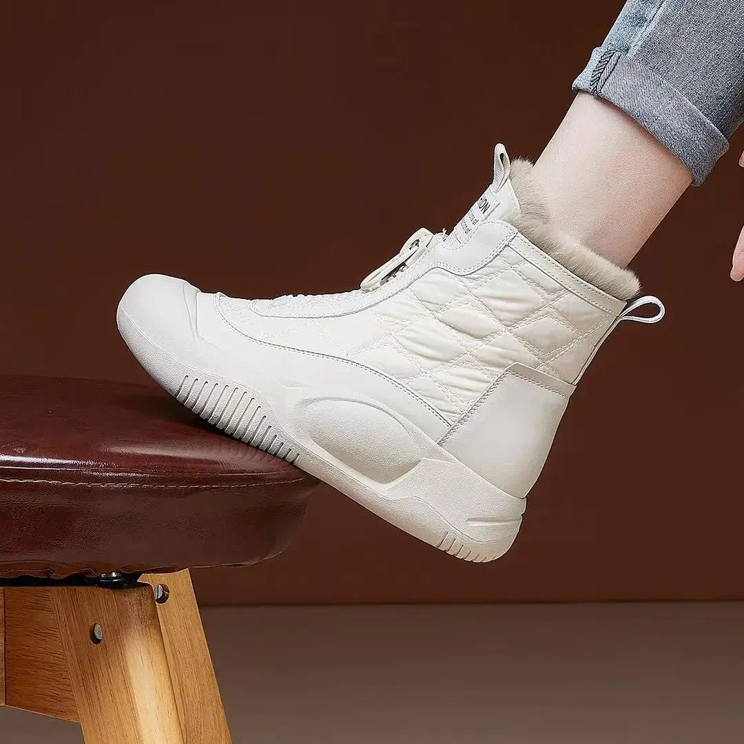 White high-top sneakers worn by a person sitting on a brown stool against a brown background